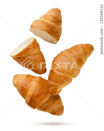 Croissants and two halves flying close-up on a white. Isolated Croissants and two halves flying close-up on a white. Isolated 130366522