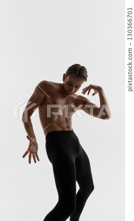 Male dancer bending body with hand raised in expressive gesture of emotional tension Male dancer bending body with hand raised in expressive gesture of emotional tension 130366701