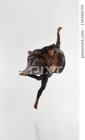 Male performer leaping in coat with dynamic arms and powerful emotional vulnerability Male performer leaping in coat with dynamic arms and powerful emotional vulnerability 130366705