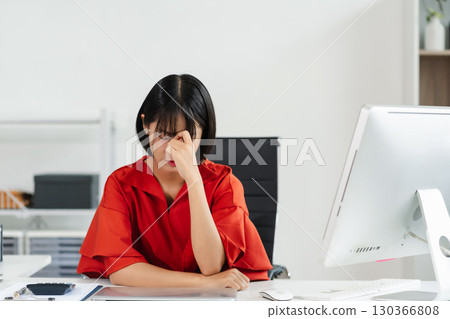 Stress businesswoman is sitting at table, under stress from working. Stress businesswoman is sitting at table, under stress from working. 130366808