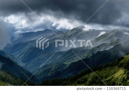Majestic mountain landscape under a dramatic sky at dusk Majestic mountain landscape under a dramatic sky at dusk 130368715