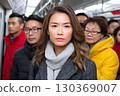 Young woman standing on crowded subway train during rush hour 130369007