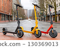 Electric scooters parked on city sidewalk awaiting riders 130369013