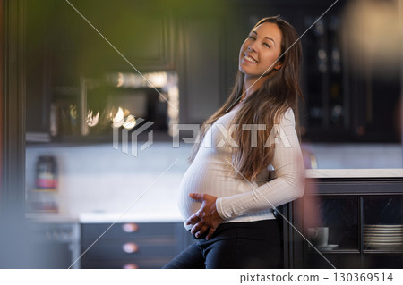 Relaxed pregnant woman enjoying the warmth of her home during a peaceful moment 130369514