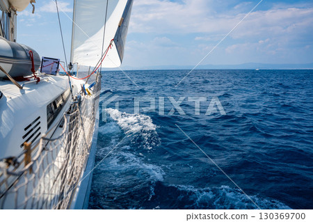 Side of a sailing yacht cutting through the sea with full sails near Croatia. Motion, freedom, sailing lifestyle and adventure on the open water. 130369700