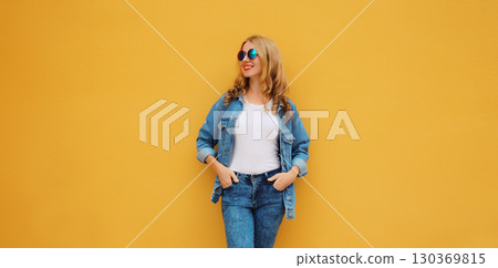 Happy stylish beautiful young woman, modern girl looking away posing on bright yellow background 130369815