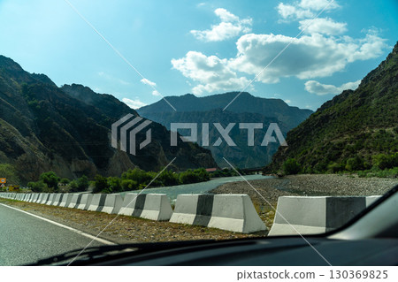 A view of a mountain range with a road in the distance 130369825