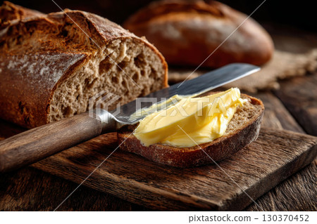 Fresh butter topping homemade bread with a butter knife 130370452