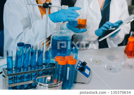 Collaboration, tablet or science with people in lab together for research or development. Innovation, tech and microscope with scientist team in clinical trial for planning or medical investigation Collaboration, tablet or science with people in lab together for research or development. Innovation, tech and microscope with scientist team in clinical trial for planning or medical investigation 130370634