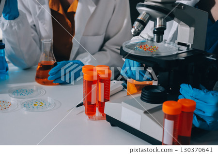 Collaboration, tablet or science with people in lab together for research or development. Innovation, tech and microscope with scientist team in clinical trial for planning or medical investigation 130370641
