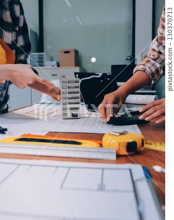 Construction and structure concept of engineer working drawing on blueprint meeting for project working with partner on model building and engineering tools in working site, construction concept. 130370713