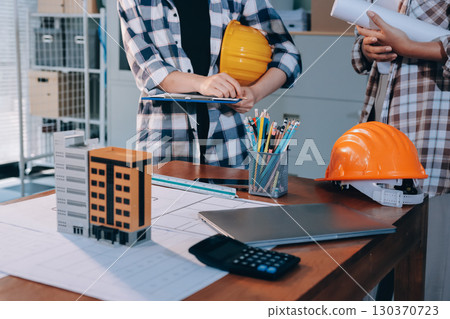 Construction and structure concept of engineer working drawing on blueprint meeting for project working with partner on model building and engineering tools in working site, construction concept. 130370723