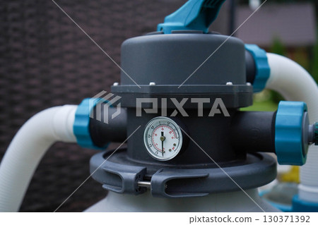 The pump responsible for filtering and ozonating to maintain a pristine outdoor swimming pool. 130371392