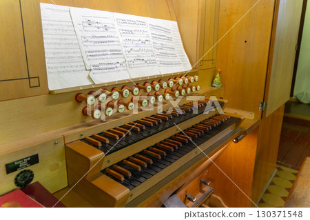 Antique organ keyboard and controls in a Lutheran church. Antique organ keyboard and controls in a Lutheran church. 130371548
