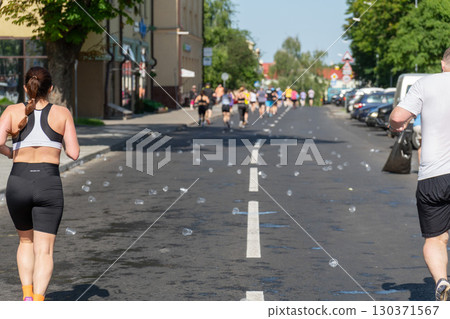 Numerous used plastic cups discarded on the asphalt after a city marathon 130371567