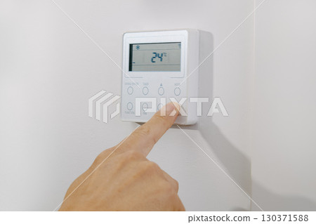 man turning on or off the air conditioning 130371588