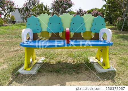 A park landscape with a cute wooden bench and lawn 130372067