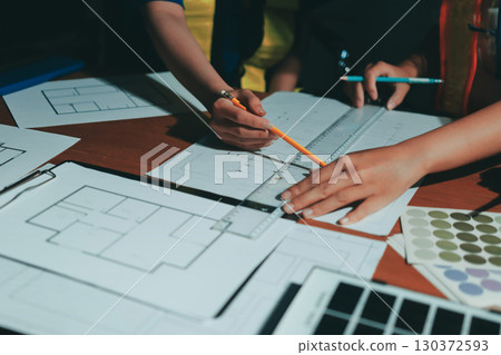 Closeup of team of industrial engineers meeting analyze machinery blueprints consult project on table in manufacturing factory. Working in manufacturing plant or production plant. 130372593