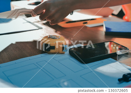 Closeup of team of industrial engineers meeting analyze machinery blueprints consult project on table in manufacturing factory. Working in manufacturing plant or production plant. 130372605