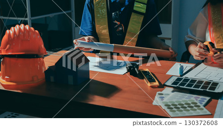 Closeup of team of industrial engineers meeting analyze machinery blueprints consult project on table in manufacturing factory. Working in manufacturing plant or production plant. Closeup of team of industrial engineers meeting analyze machinery blueprints consult project on table in manufacturing factory. Working in manufacturing plant or production plant. 130372608