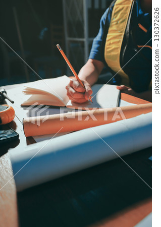 Closeup of team of industrial engineers meeting analyze machinery blueprints consult project on table in manufacturing factory. Working in manufacturing plant or production plant. 130372626