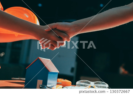 Closeup of team of industrial engineers meeting analyze machinery blueprints consult project on table in manufacturing factory. Working in manufacturing plant or production plant. 130372667