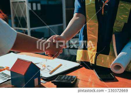 Closeup of team of industrial engineers meeting analyze machinery blueprints consult project on table in manufacturing factory. Working in manufacturing plant or production plant. 130372669