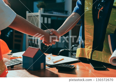 Closeup of team of industrial engineers meeting analyze machinery blueprints consult project on table in manufacturing factory. Working in manufacturing plant or production plant. 130372670