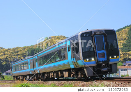 The Ashizuri express train runs along a curve under the blue sky 130372983