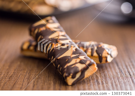 Sfogliatine glassate with chocolate. Italian crispy dessert on wooden table. 130373041