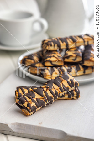 Sfogliatine glassate with chocolate. Italian crispy dessert on white table. 130373055