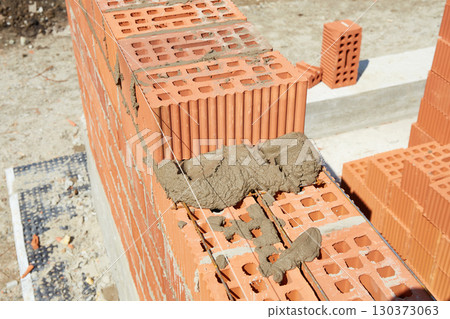Brickwork construction in progress at a building site during daylight hours 130373063