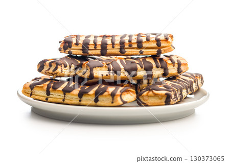 Sfogliatine glassate with chocolate. Italian crispy dessert on plate isolated on white background. Sfogliatine glassate with chocolate. Italian crispy dessert on plate isolated on white background. 130373065