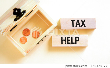 Tax help symbol. Concept words Tax help on wooden blocks on a beautiful white table white background. Wooden chest with coins. Business, support and tax help concept. Copy space. Tax help symbol. Concept words Tax help on wooden blocks on a beautiful white table white background. Wooden chest with coins. Business, support and tax help concept. Copy space. 130373177