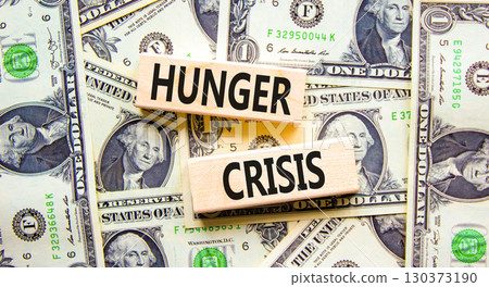 Hunger crisis symbol. Concept words Hunger crisis on wooden blocks on a beautiful background from dollar bills. Dollar bills. Business, support and Hunger crisis concept. Copy space. 130373190