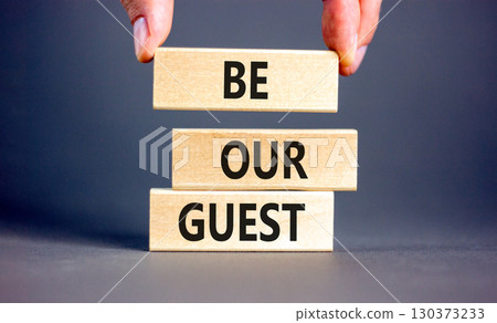 Be our guest symbol. Concept words Be our guest on beautiful wooden block. Businessman's hand. Beautiful grey background. Business and be our guest concept. Copy space. Be our guest symbol. Concept words Be our guest on beautiful wooden block. Businessman's hand. Beautiful grey background. Business and be our guest concept. Copy space. 130373233