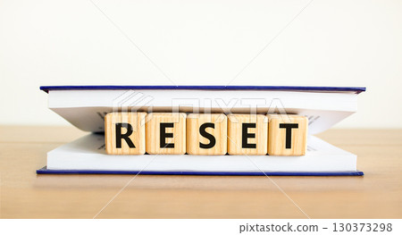 Reset symbol. Concept word Reset on beautiful wooden blocks in book. Beautiful wooden table white background. Business lifestyle reset concept. Copy space. Reset symbol. Concept word Reset on beautiful wooden blocks in book. Beautiful wooden table white background. Business lifestyle reset concept. Copy space. 130373298