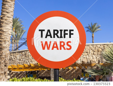 Trade tariff wars symbol. Concept word Tariff wars on beautiful red and white road sign. Beautiful palm tree and market blue sky background. Business trade tariff wars concept. Copy space. 130373323