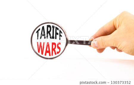 Trade tariff wars symbol. Concept word Tariff wars on beautiful magnifying glass. Businessman's hand. Beautiful paper background. Black magnifying glass. Business trade tariff wars concept. Copy space Trade tariff wars symbol. Concept word Tariff wars on beautiful magnifying glass. Businessman's hand. Beautiful paper background. Black magnifying glass. Business trade tariff wars concept. Copy space 130373352