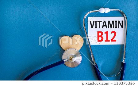 Vitamin B12 symbol. Concept words Vitamin B12 on beautiful white card. Wooden heart and stethoscope. Beautiful blue background. Medical healthy lifestyle Vitamin B12 concept. Vitamin B12 symbol. Concept words Vitamin B12 on beautiful white card. Wooden heart and stethoscope. Beautiful blue background. Medical healthy lifestyle Vitamin B12 concept. 130373380