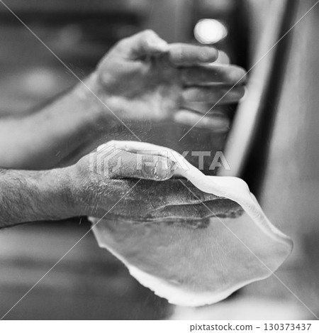 Chef's hands spraying flour over the dough. Kneading dough. chef kitchen dough Chef's hands spraying flour over the dough. Kneading dough. chef kitchen dough 130373437