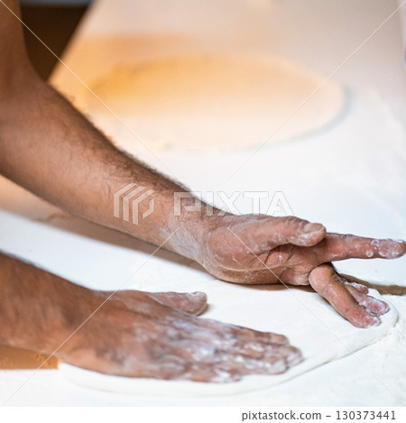 Cook hands kneading dough, piece of dough with white flour. close up on hands 130373441