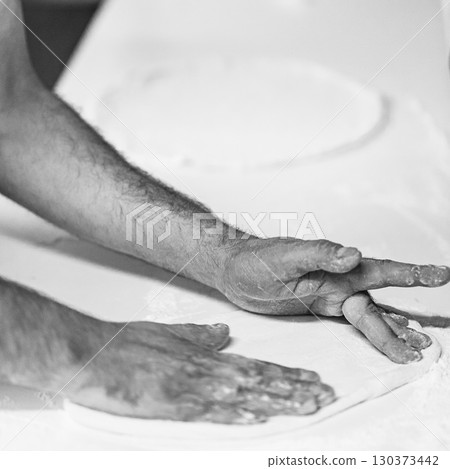 Cook hands kneading dough, piece of dough with white flour. close up on hands 130373442