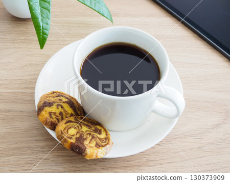 Hot coffee, marble cookies and a tablet on the table Hot coffee, marble cookies and a tablet on the table 130373909