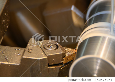 Close up scene the lathe machine finish cut metal shaft parts with liquid coolant method. 130373965