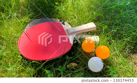 Table tennis rackets and balls on green grass, outdoor leisure Table tennis rackets and balls on green grass, outdoor leisure 130374453