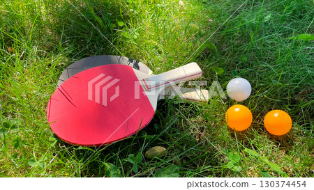 Table tennis rackets and balls on green grass, outdoor leisure Table tennis rackets and balls on green grass, outdoor leisure 130374454