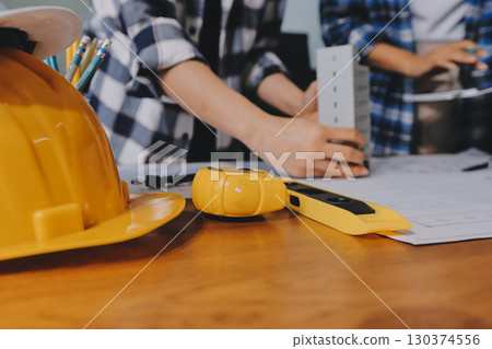Construction and structure concept of engineer working drawing on blueprint meeting for project working with partner on model building and engineering tools in working site, construction concept. 130374556