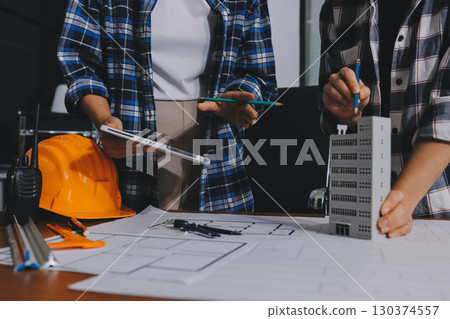 Construction and structure concept of engineer working drawing on blueprint meeting for project working with partner on model building and engineering tools in working site, construction concept. 130374557