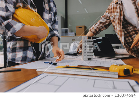 Construction and structure concept of engineer working drawing on blueprint meeting for project working with partner on model building and engineering tools in working site, construction concept. Construction and structure concept of engineer working drawing on blueprint meeting for project working with partner on model building and engineering tools in working site, construction concept. 130374584